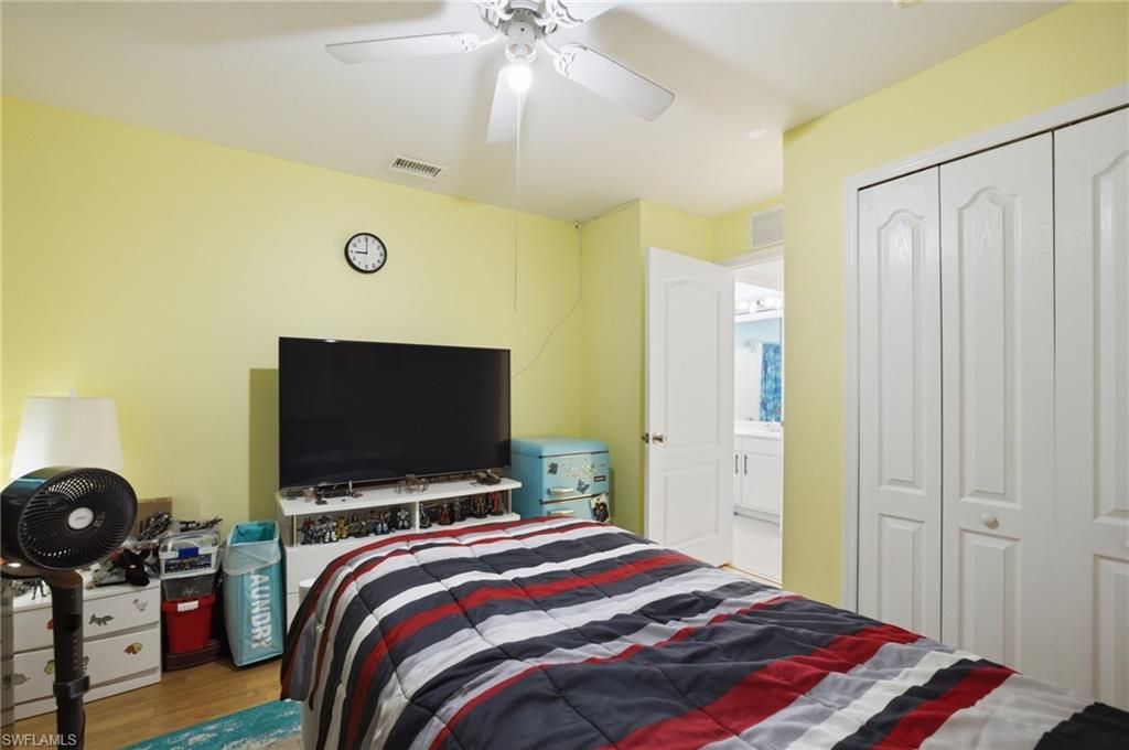 Bedroom with light wood-style floors, a ceiling fan, and a closet