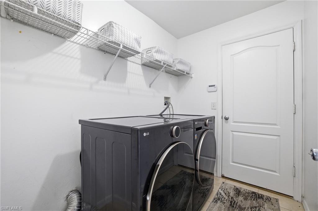 Laundry room featuring independent washer and dryer and light tile patterned floors