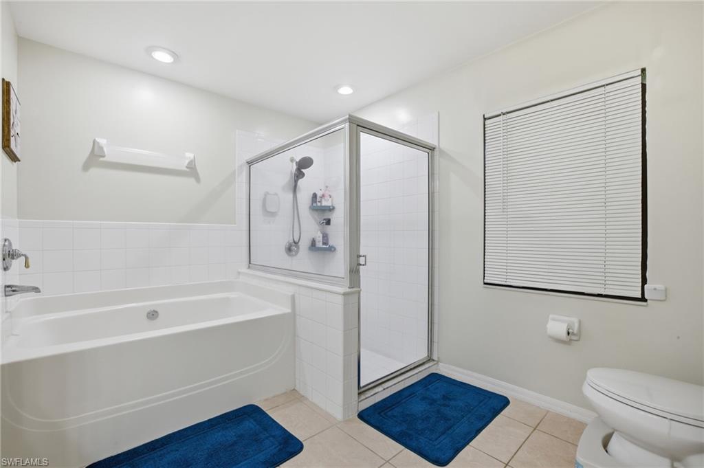 Bathroom with a bath, a shower stall, light tile patterned flooring, and recessed lighting