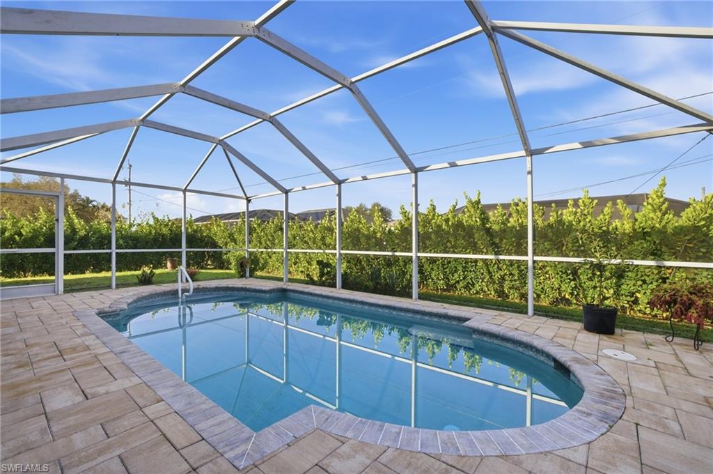 Swimming pool with a sunroom, glass enclosure, and a patio