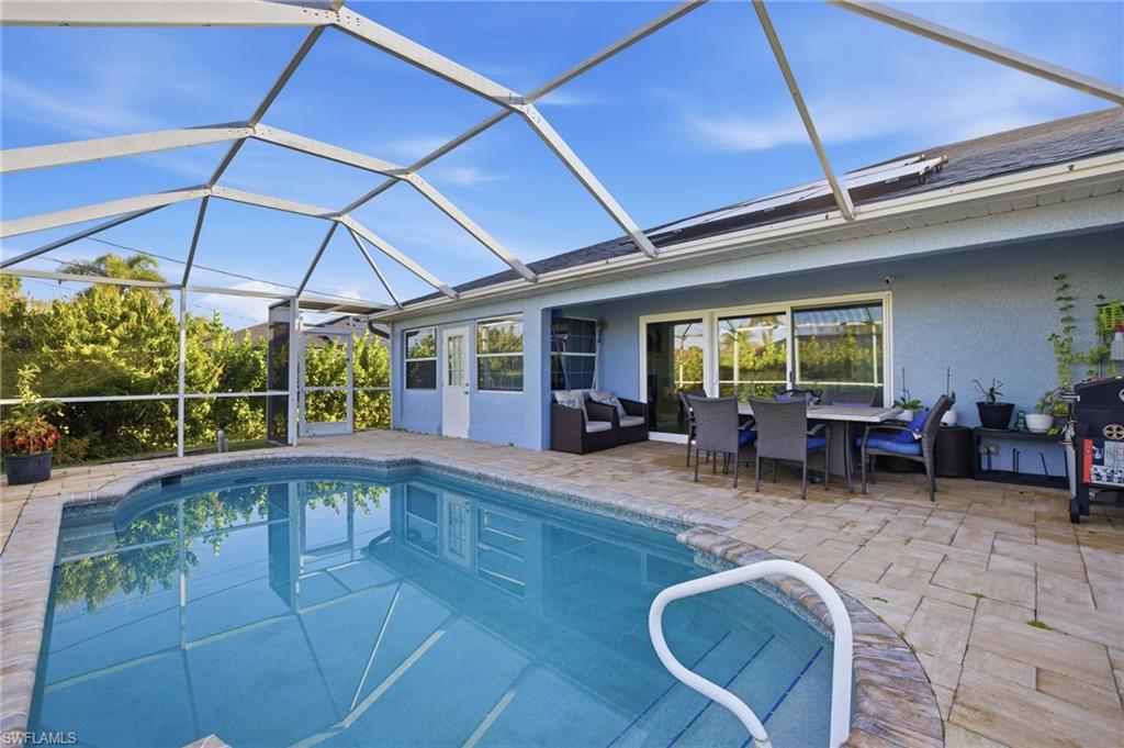 Outdoor pool featuring outdoor dining area, a sunroom, a lanai, and a patio area