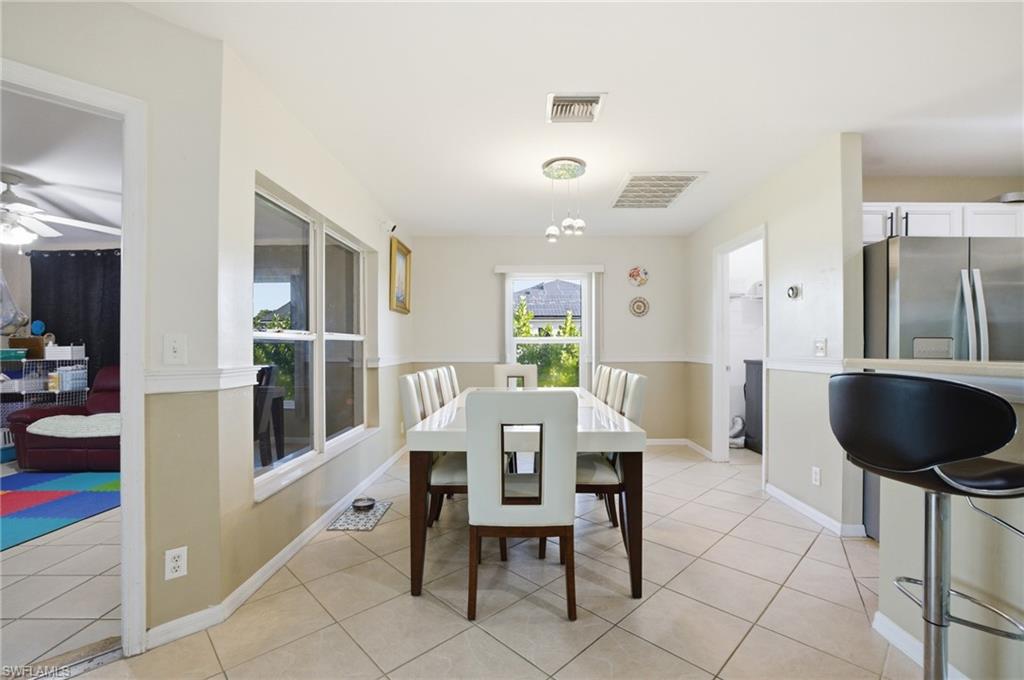 Dining area with light tile patterned flooring and a ceiling fan