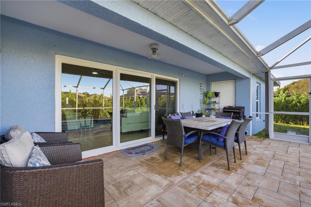 Sunroom / solarium with outdoor dining area, a patio, and a ceiling fan