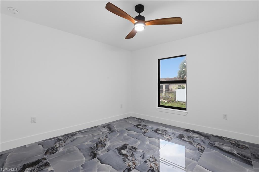 Empty room with baseboards and ceiling fan