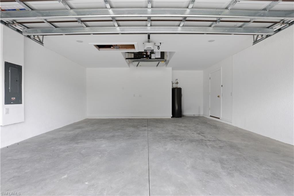 Garage featuring electric panel and water heater