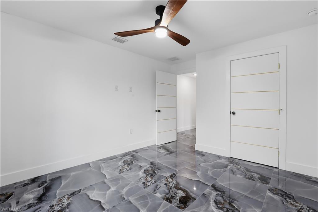 Unfurnished bedroom with ceiling fan and baseboards