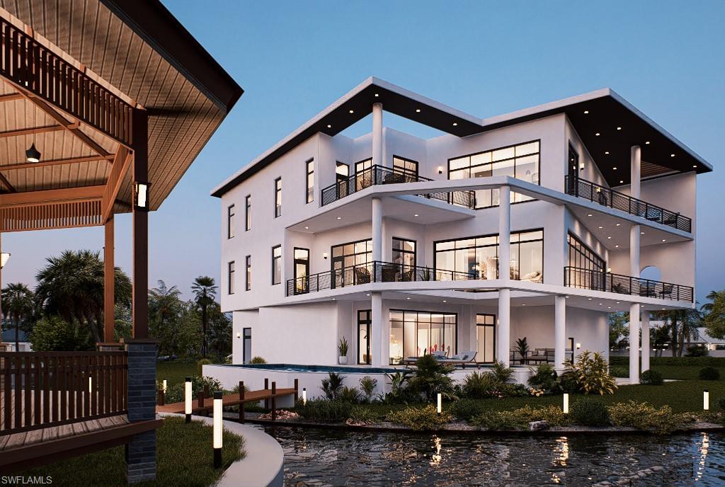 Back of property at dusk featuring stucco siding, a balcony, and an outdoor pool