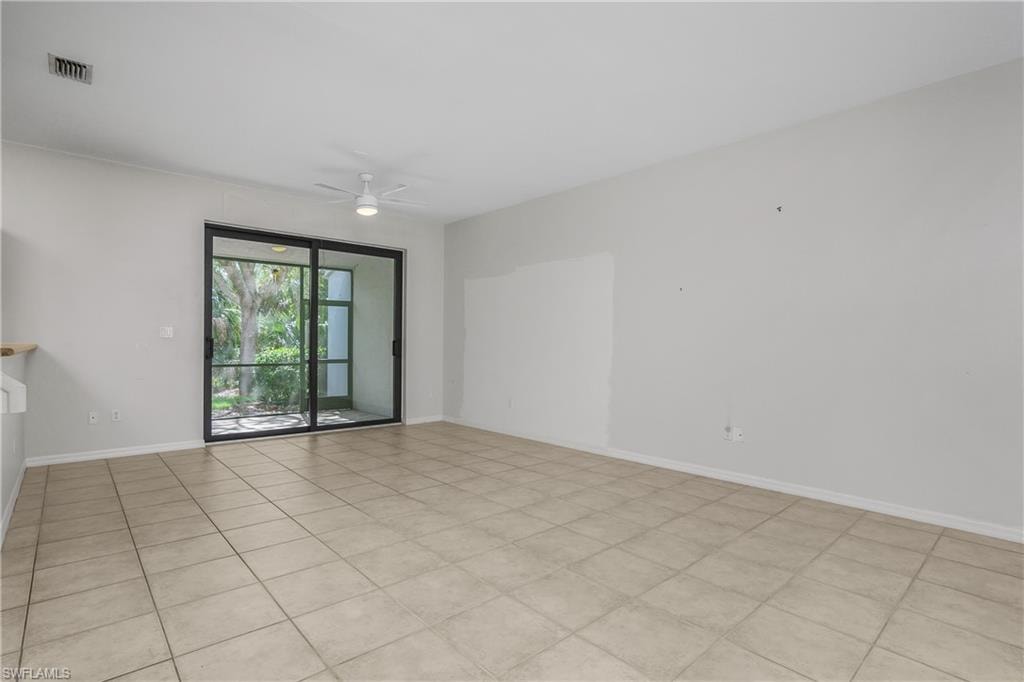 Spare room with ceiling fan and light tile patterned floors