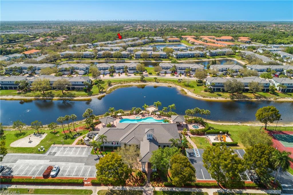 Aerial perspective of suburban area featuring a pool area and a nearby body of water