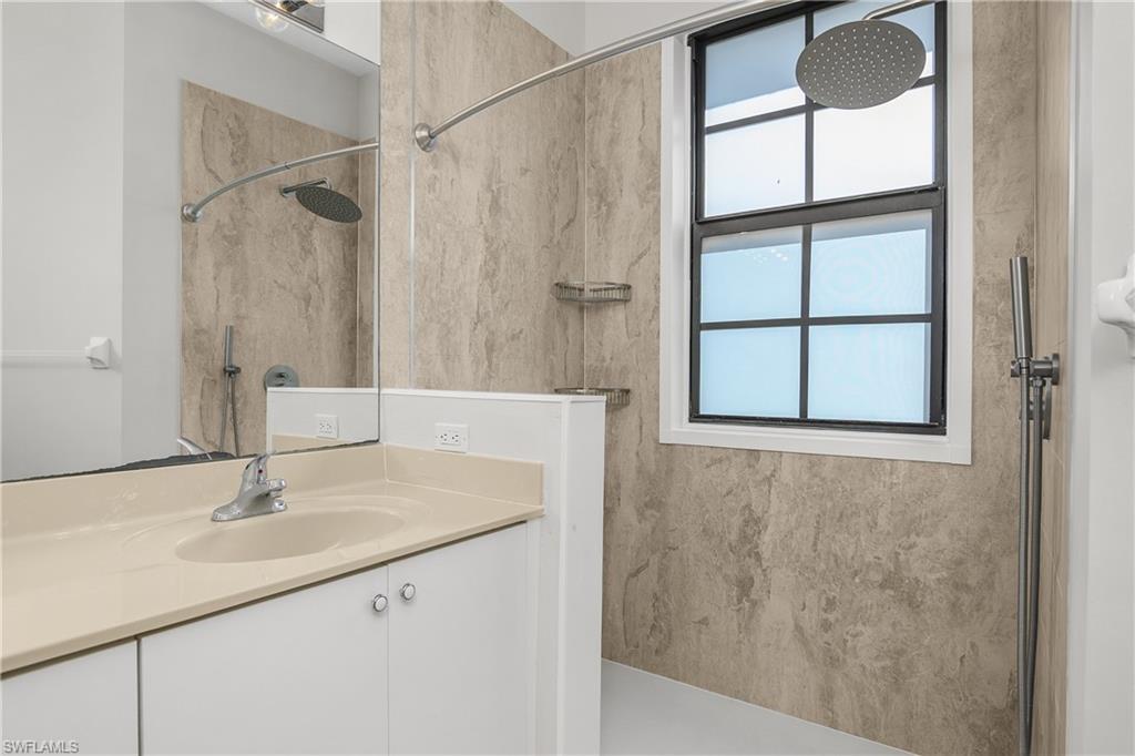 Full bathroom with a marble finish shower and vanity