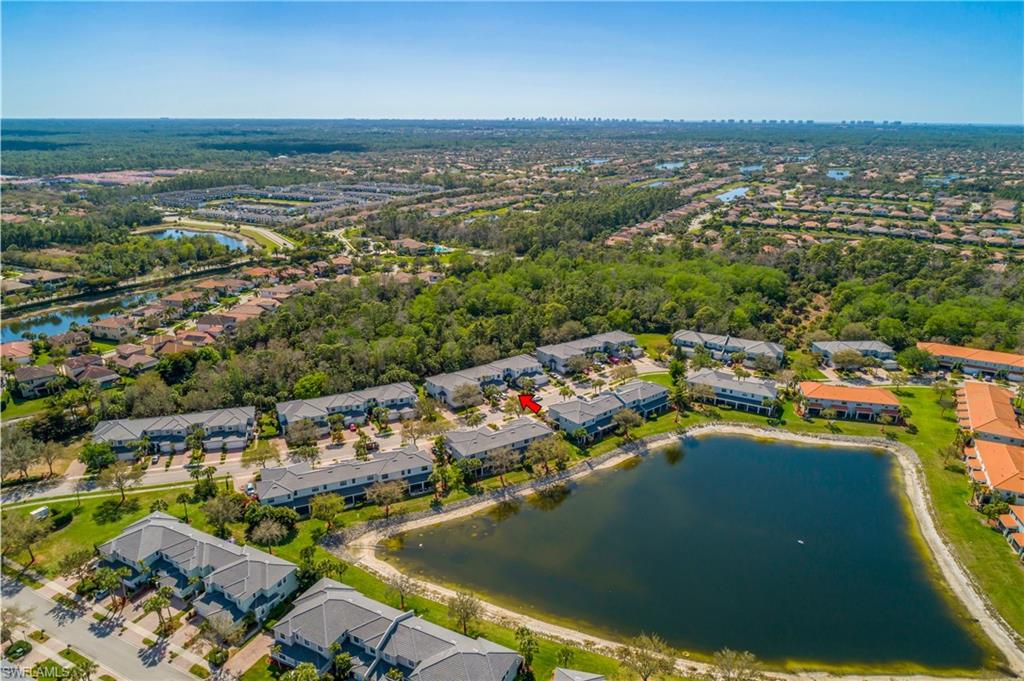 Aerial view of property's location with a nearby body of water and nearby suburban area