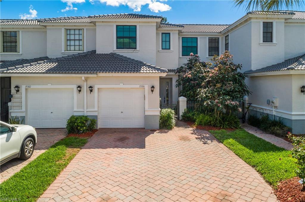 Mediterranean / spanish home with decorative driveway, stucco siding, and a tile roof