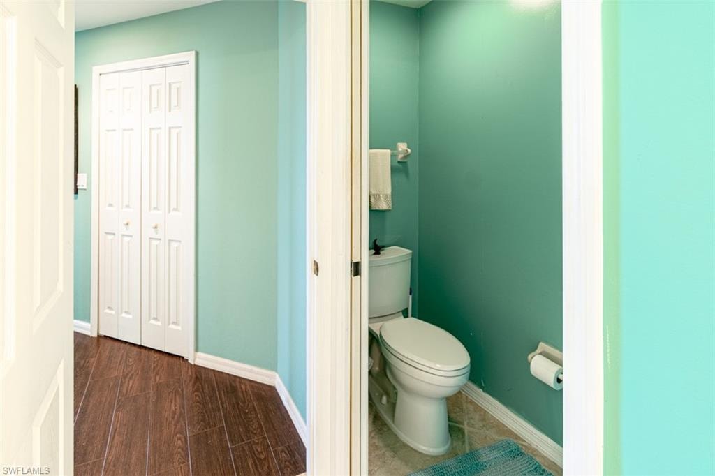 Bathroom featuring toilet and dark wood-style flooring