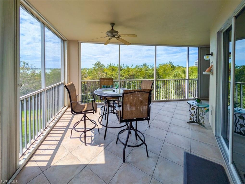 Sunroom / solarium featuring tile patterned flooring, healthy amount of natural light, and expansive windows