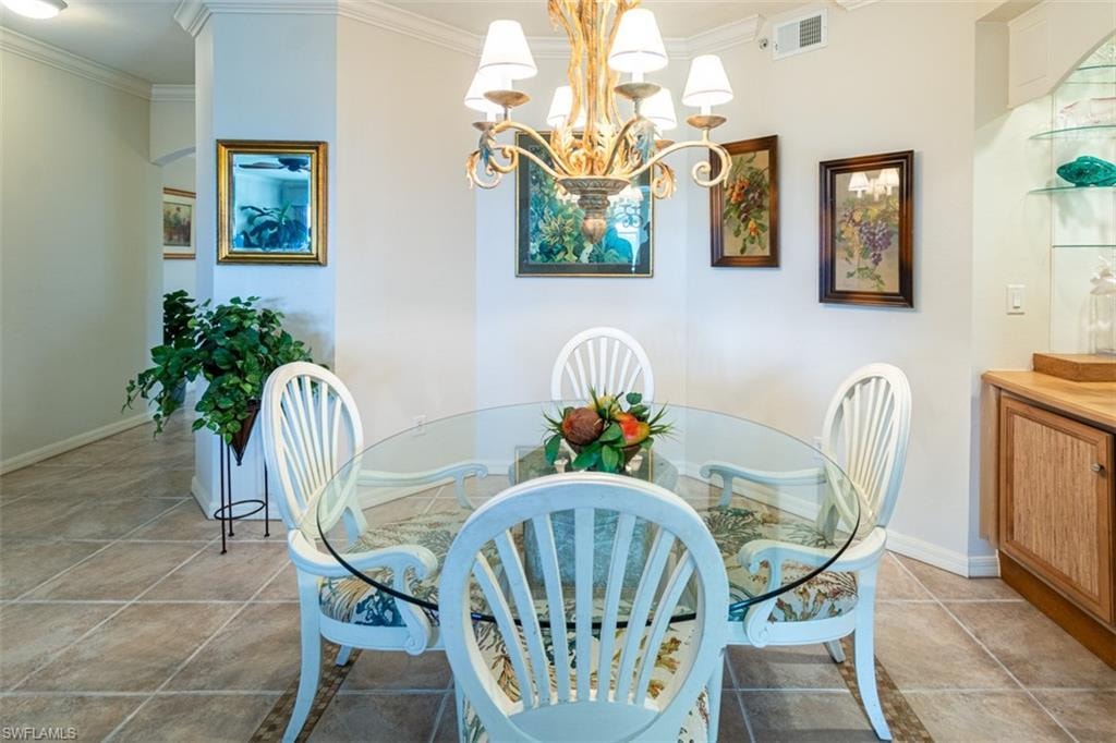 Dining space with ornamental molding and hanging lights