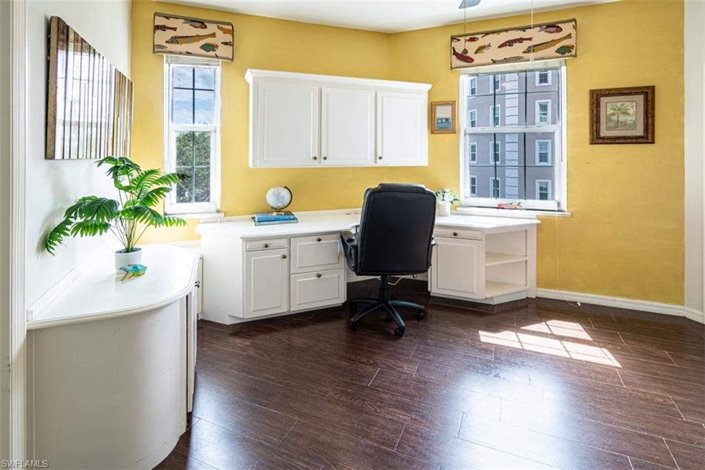 Home office featuring dark wood-style flooring and a ceiling fan