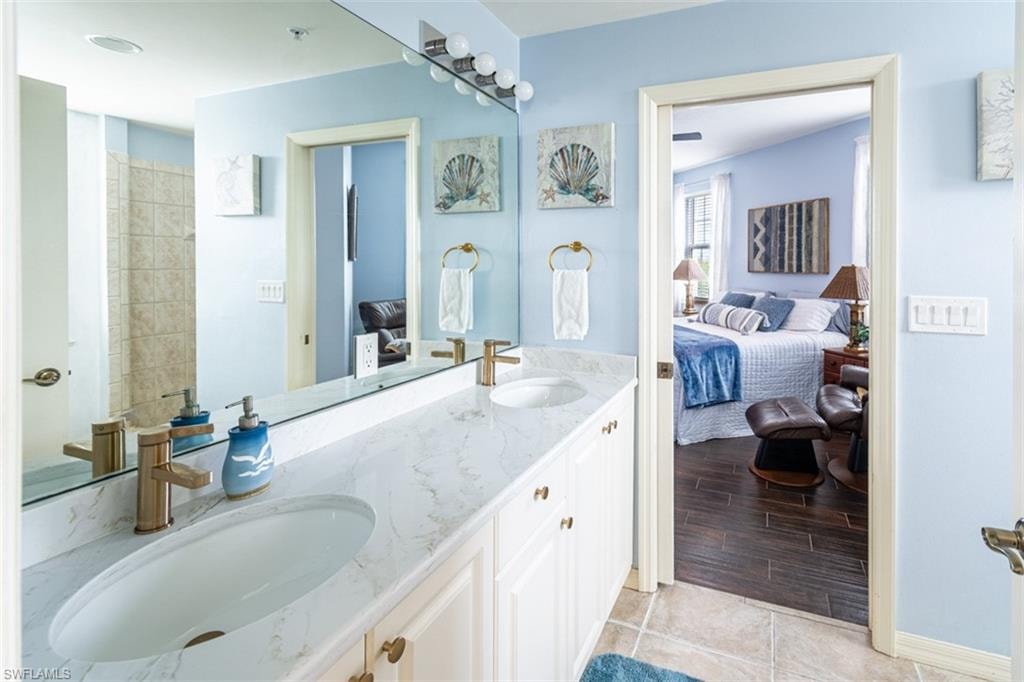 Ensuite bathroom with double vanity and light tile patterned floors