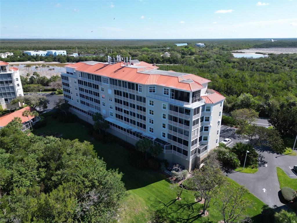 Drone / aerial view of apartment complex and a heavily wooded area