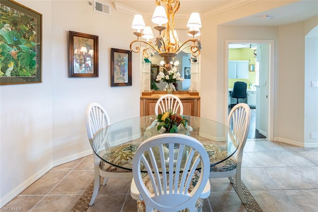 Dining space with hanging lights and ornamental molding