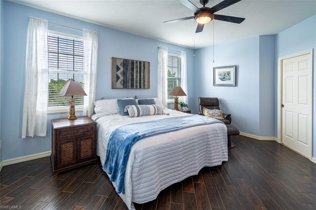 Bedroom with dark wood-style flooring and a ceiling fan