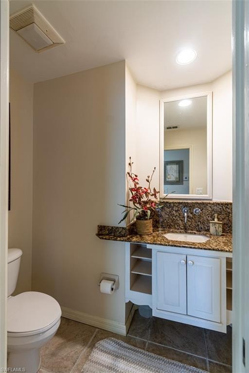 Half bathroom with vanity and light tile patterned floors