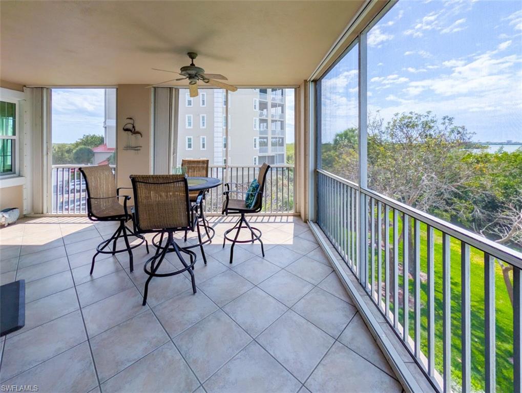 Sunroom with ceiling fan, a balcony, and healthy amount of natural light
