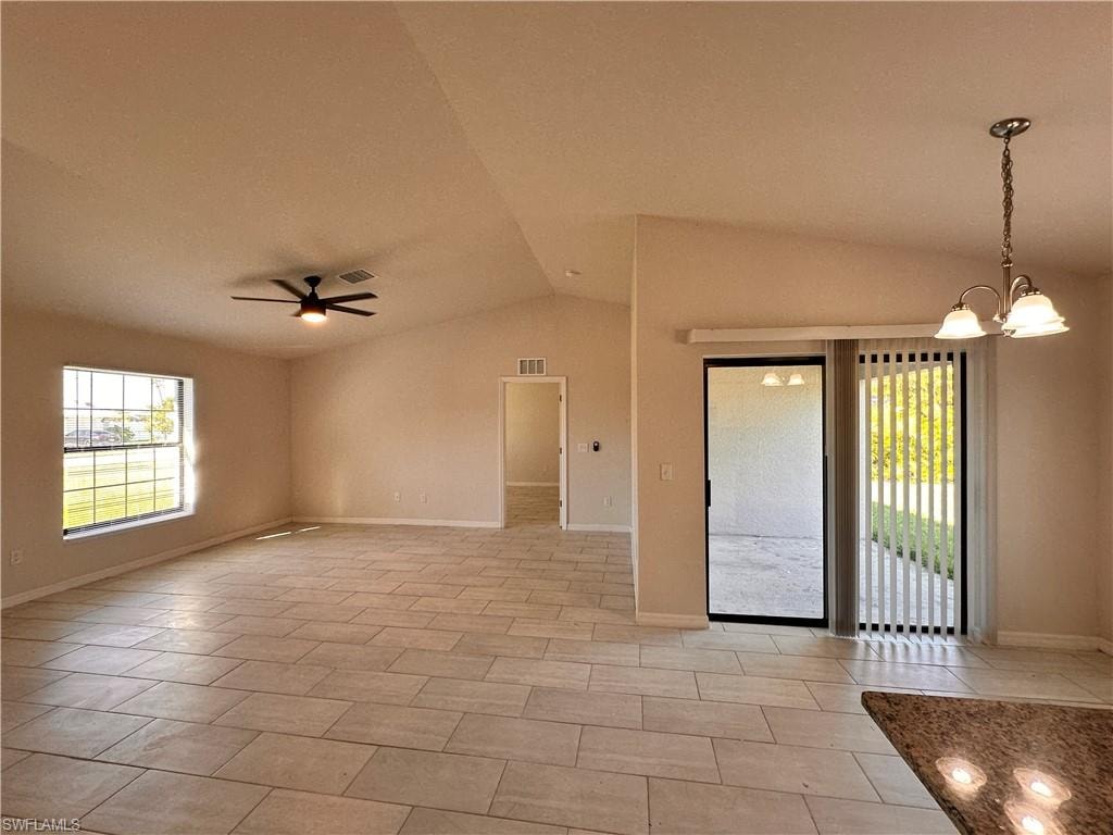 Empty room with suspended lighting, lofted ceiling, and ceiling fan