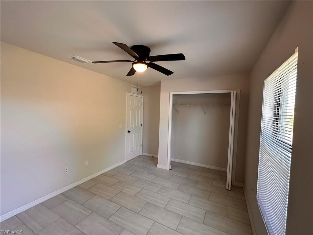 Unfurnished bedroom with a closet, a ceiling fan, and wood finish floors