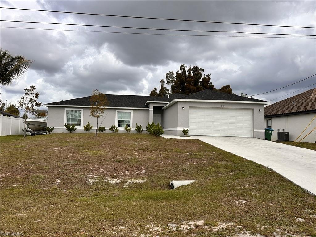 Ranch-style home with a garage, stucco siding, concrete driveway, and a front yard