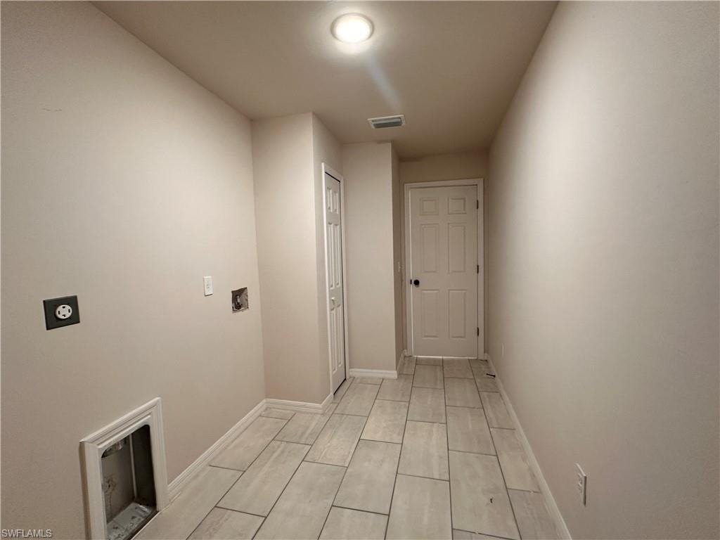 Laundry room with electric dryer hookup and baseboards