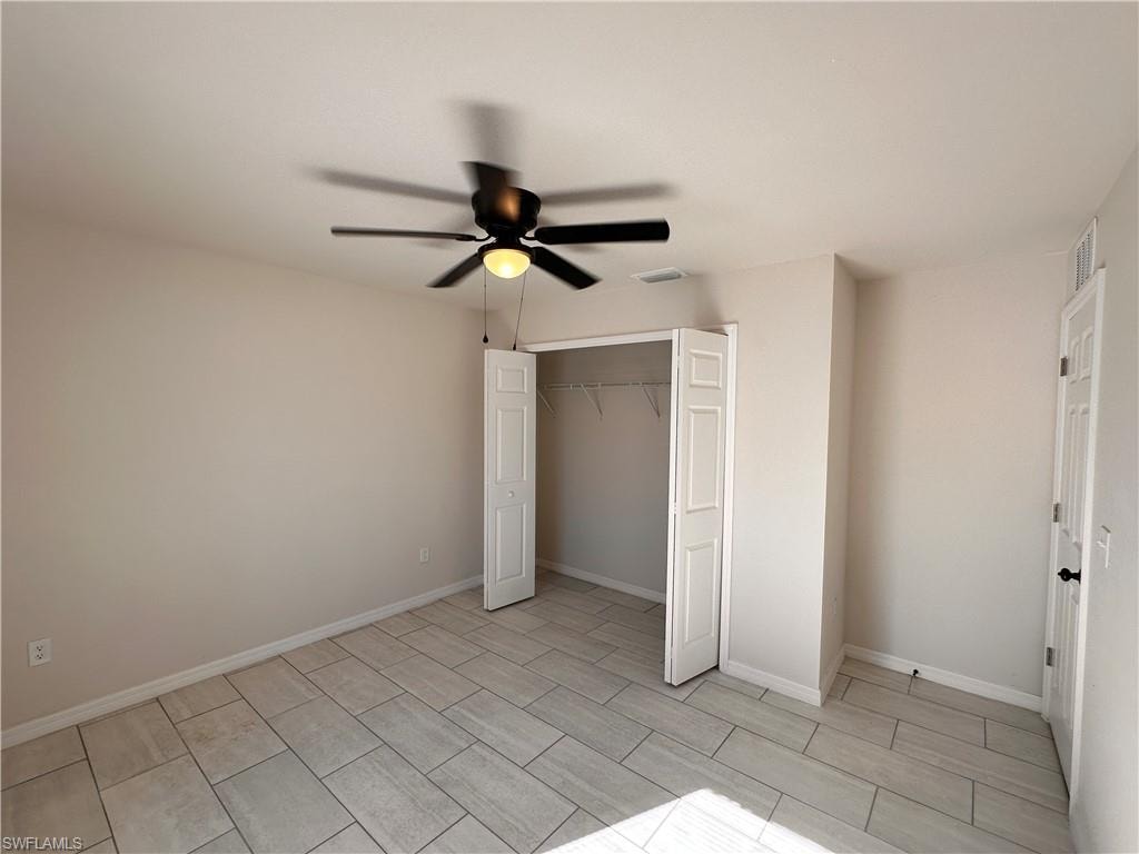 Unfurnished bedroom with a closet, a ceiling fan, and wood finish floors