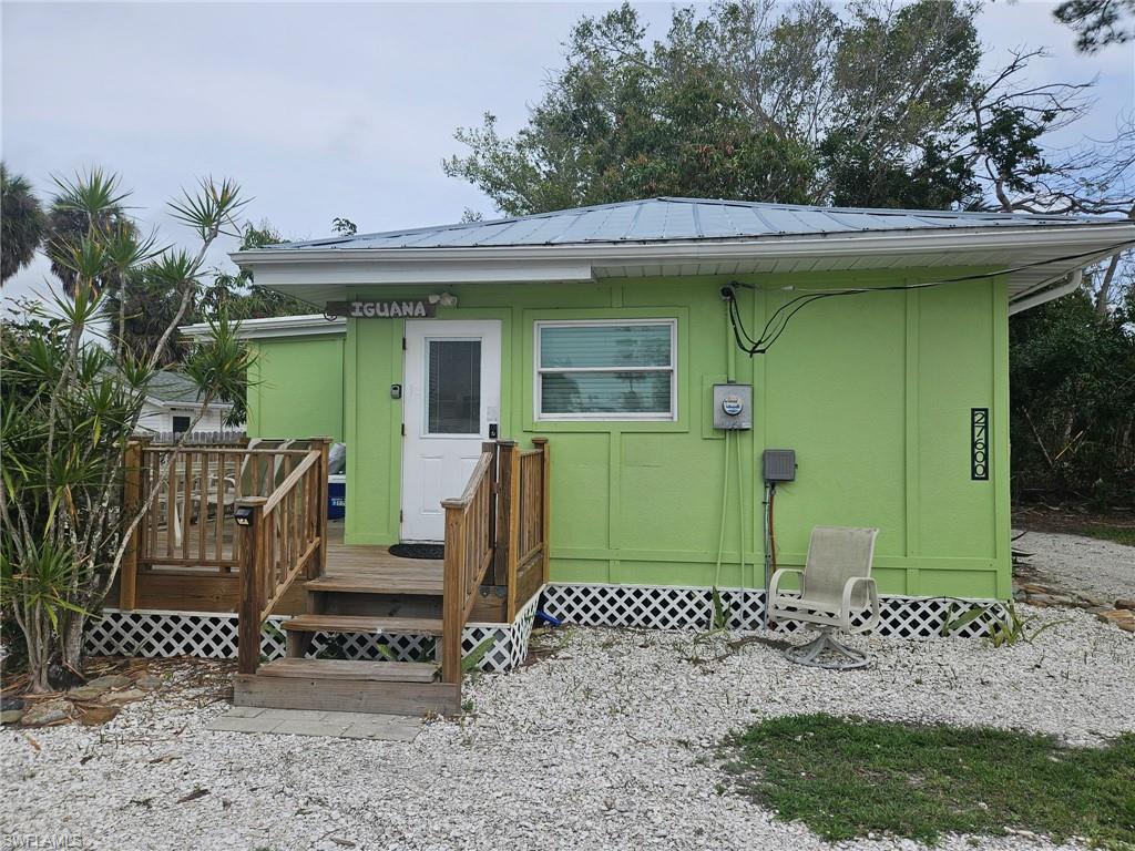 Rear view of house with a metal roof and a wooden deck