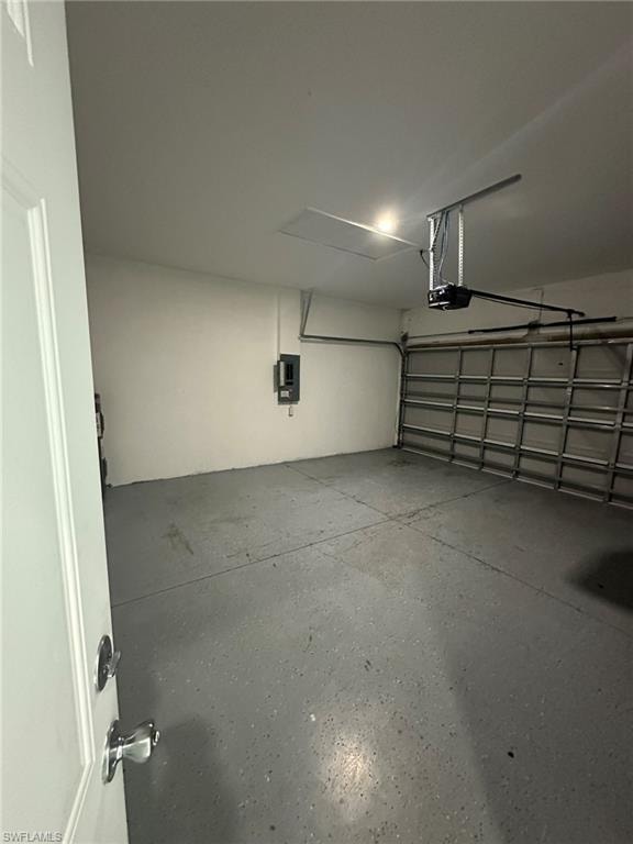 Garage featuring electric panel and a garage door opener