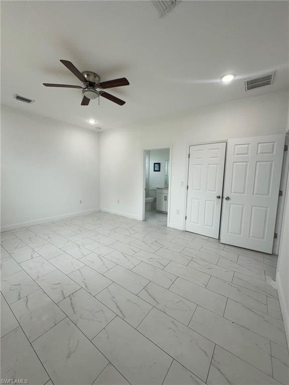Unfurnished bedroom featuring light marble finish flooring, a ceiling fan, ensuite bath, recessed lighting, and a closet