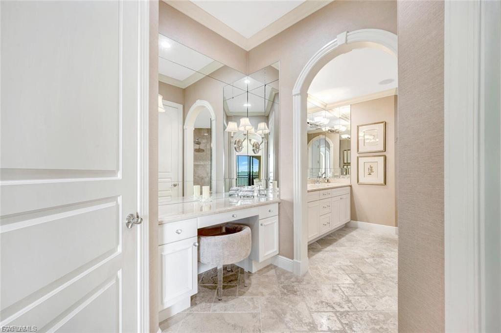 Full bathroom with vanity, crown molding, and stone tile flooring