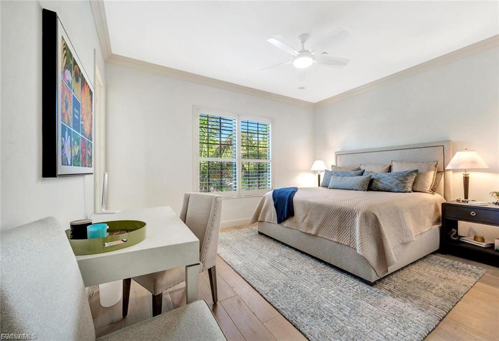 Bedroom with ornamental molding, light wood-style floors, and a ceiling fan