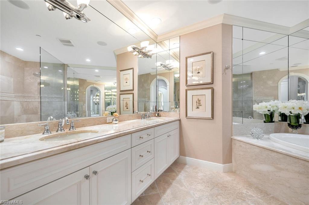 Full bathroom featuring double vanity, a bath, and a walk in shower