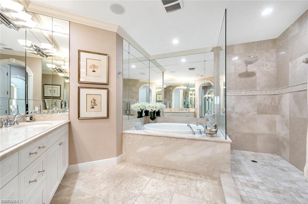 Full bath with a walk in shower, vanity, a garden tub, and crown molding