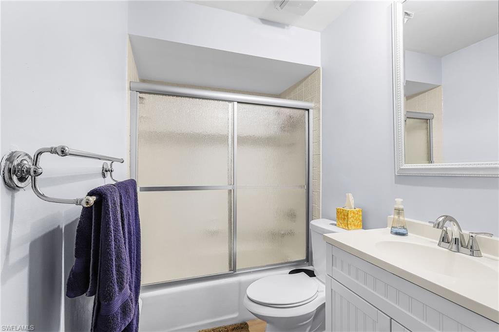 Bathroom featuring vanity and shower / bath combination with glass door