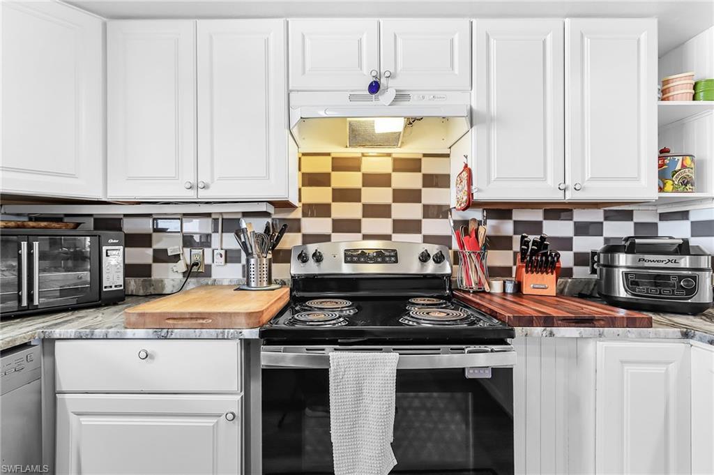 Kitchen with white cabinets, stainless steel appliances, and backsplash