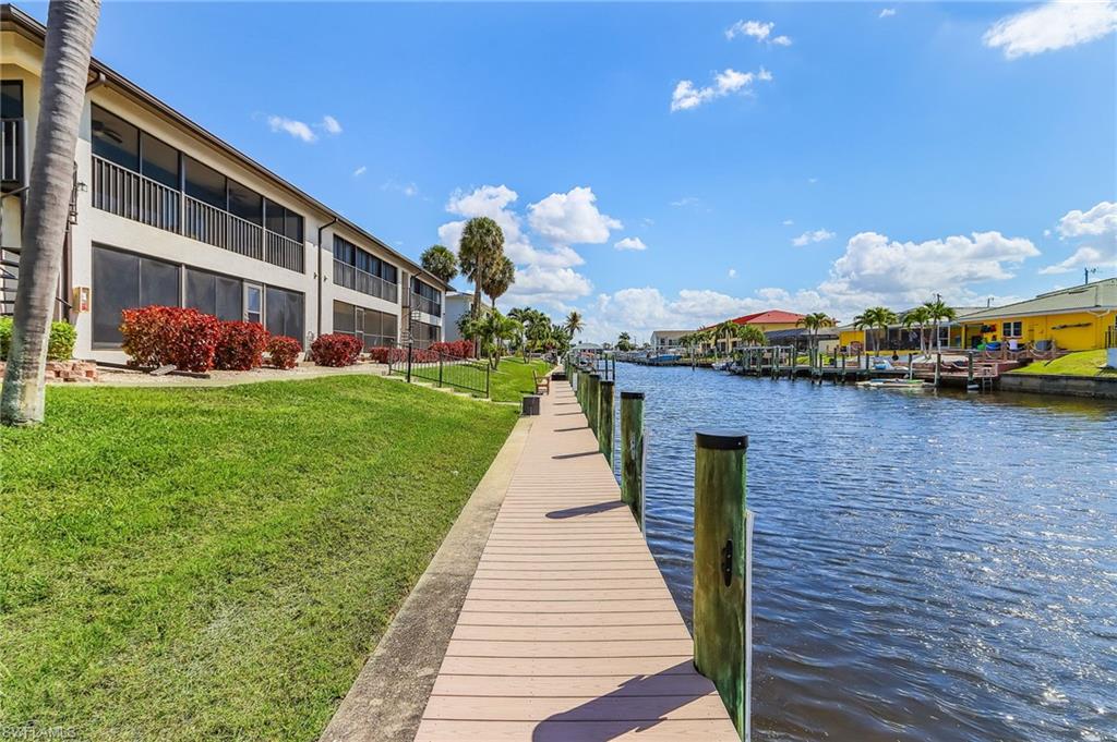 Dock area with a yard and a water view