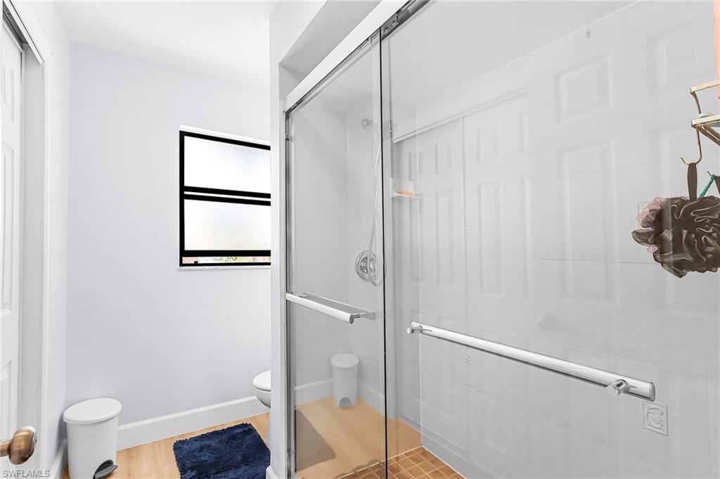 Bathroom featuring a shower stall and light wood-style flooring