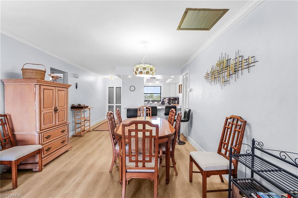 Dining area featuring crown molding and light wood-style flooring