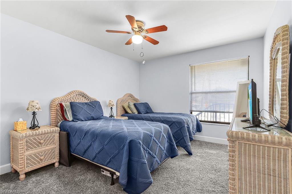 Carpeted bedroom with baseboards and a ceiling fan