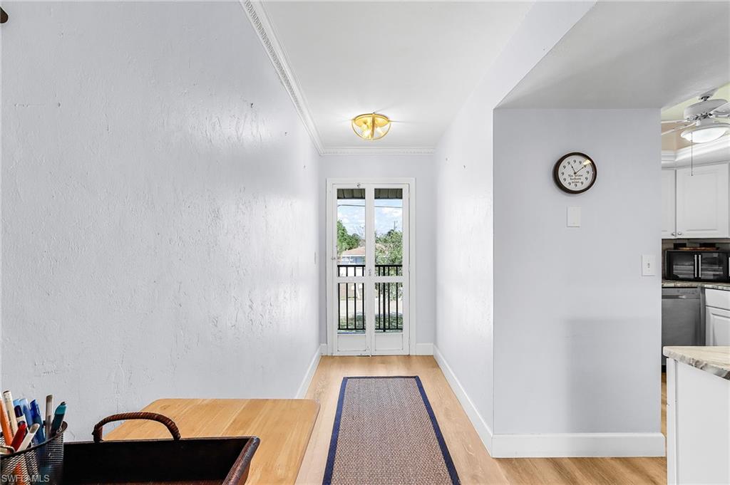 Entryway featuring crown molding, wood finished floors, ceiling fan, and a textured wall