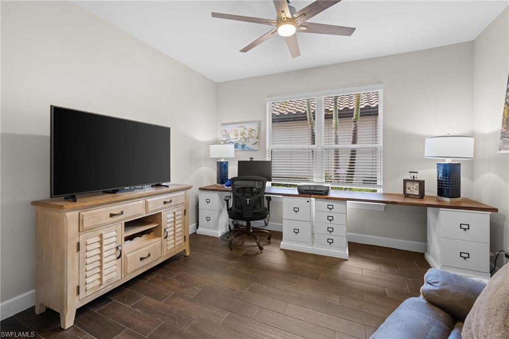 Home office featuring wood tiled floors, a ceiling fan, and built in desk