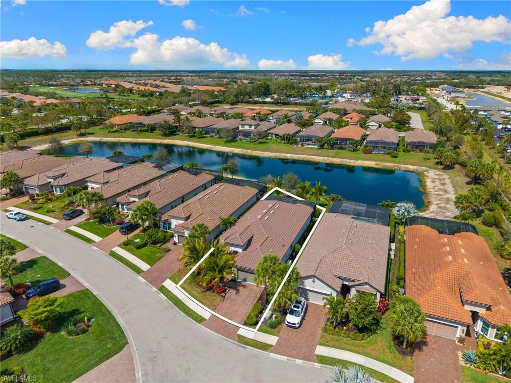 Aerial view of residential area featuring a nearby body of water and property parcel outlined