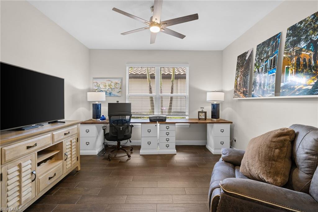 Office area featuring wood tiled floors, ceiling fan, and built in study area