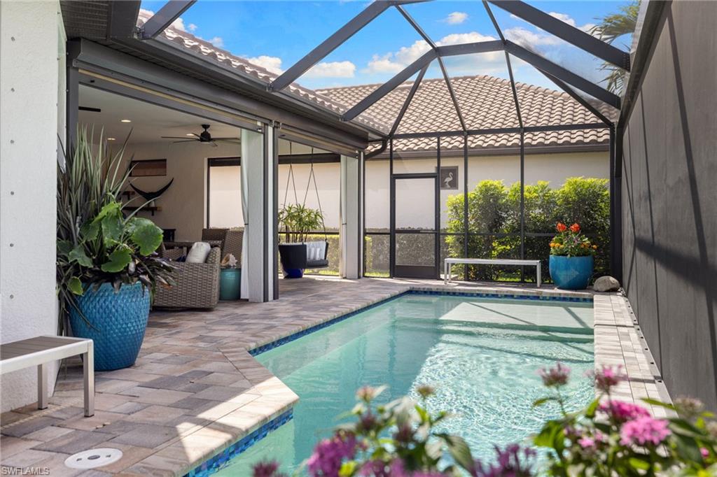 Outdoor pool with a sunroom, a lanai, a patio area, and outdoor lounge area