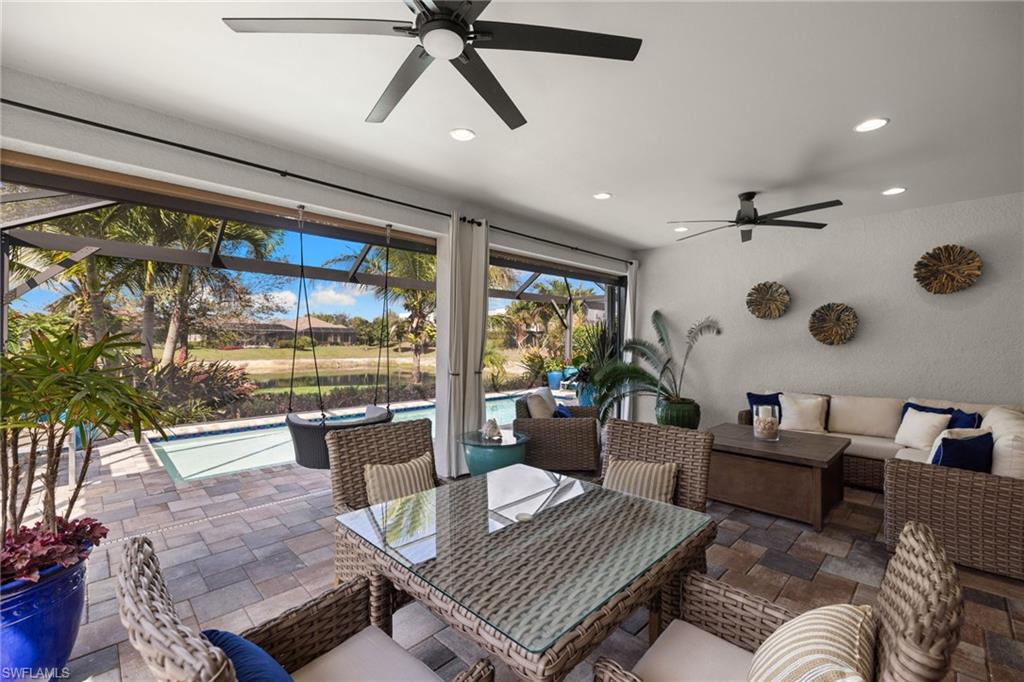View of patio with an outdoor pool, a ceiling fan, outdoor seating, a sunroom, and a lanai